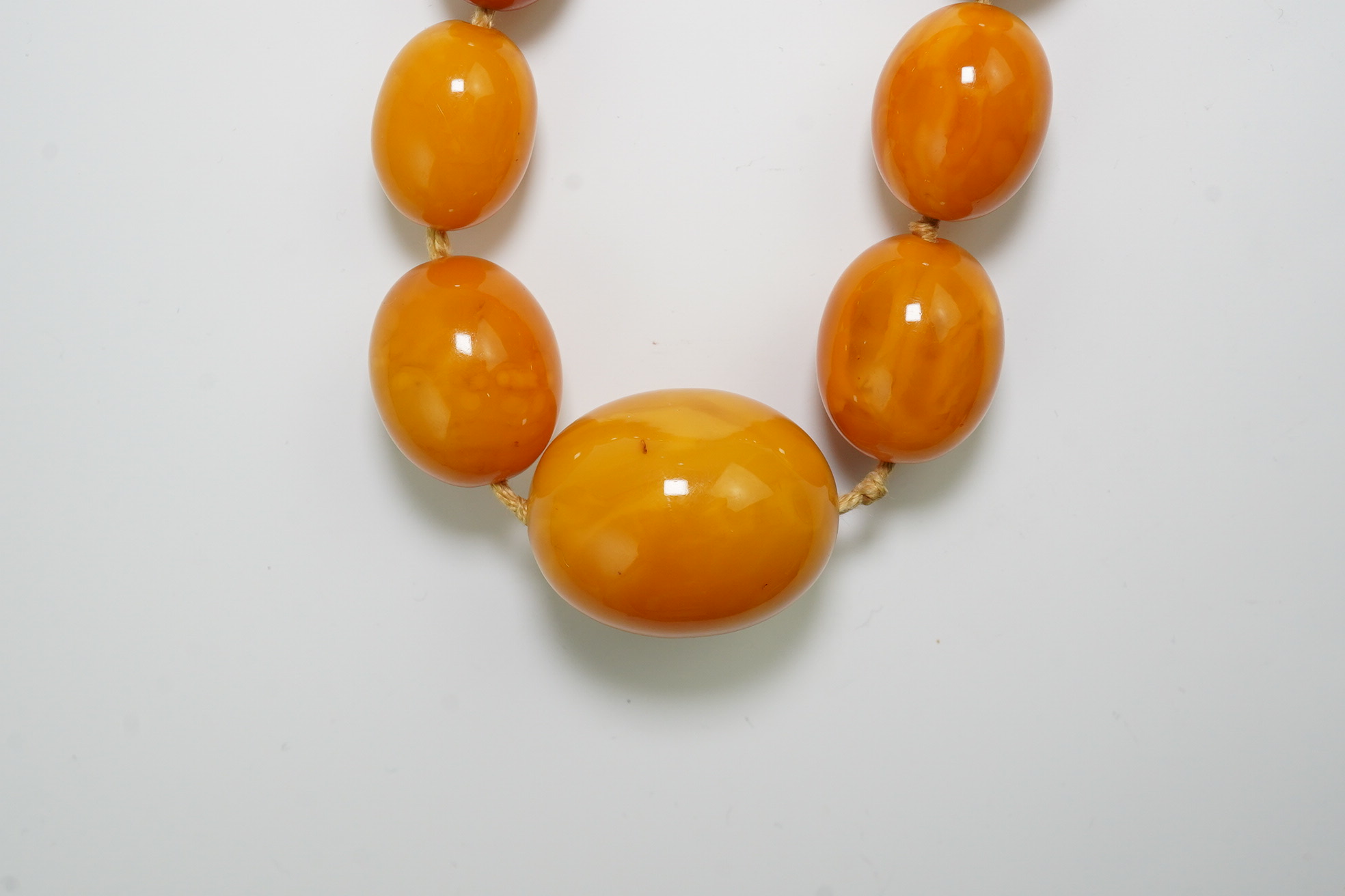 A single strand graduated oval amber bead necklace